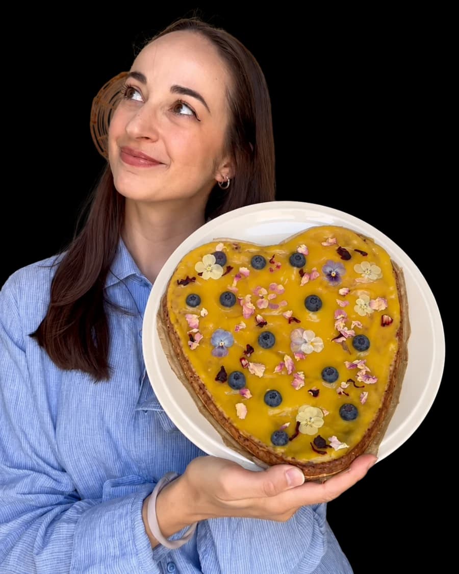 Brigitte Riedl holding a heart-shaped mango cheesecake